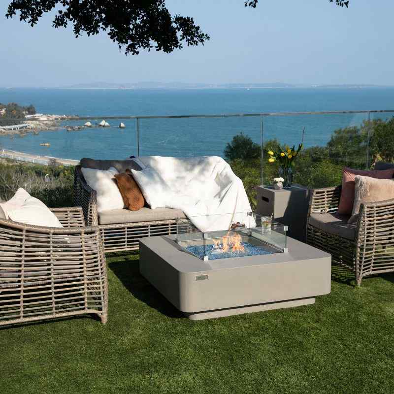 Elementi Plus Lucerne Fire Table with fame and windscreen near couch overlook balcony